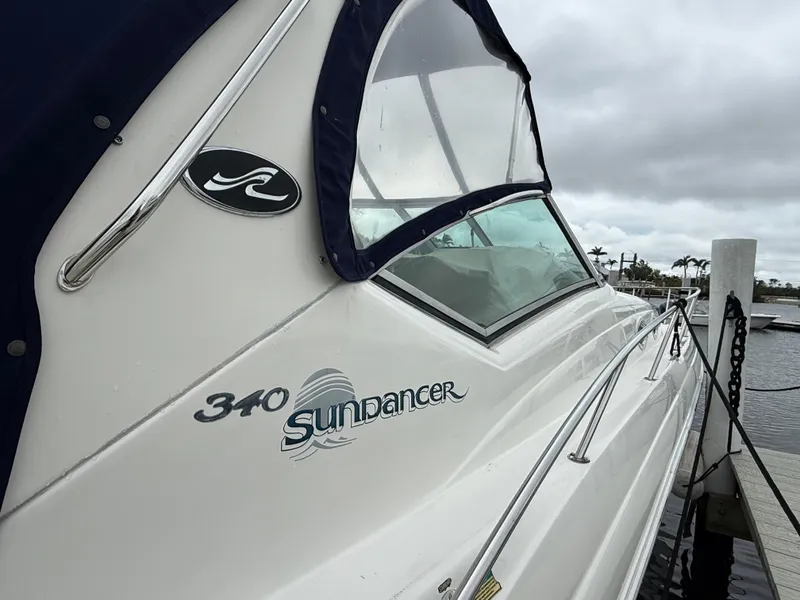 Slide: The Image of 2005 Sea Ray 340 Sundancer boat docked, featuring sleek design and logo. - 30