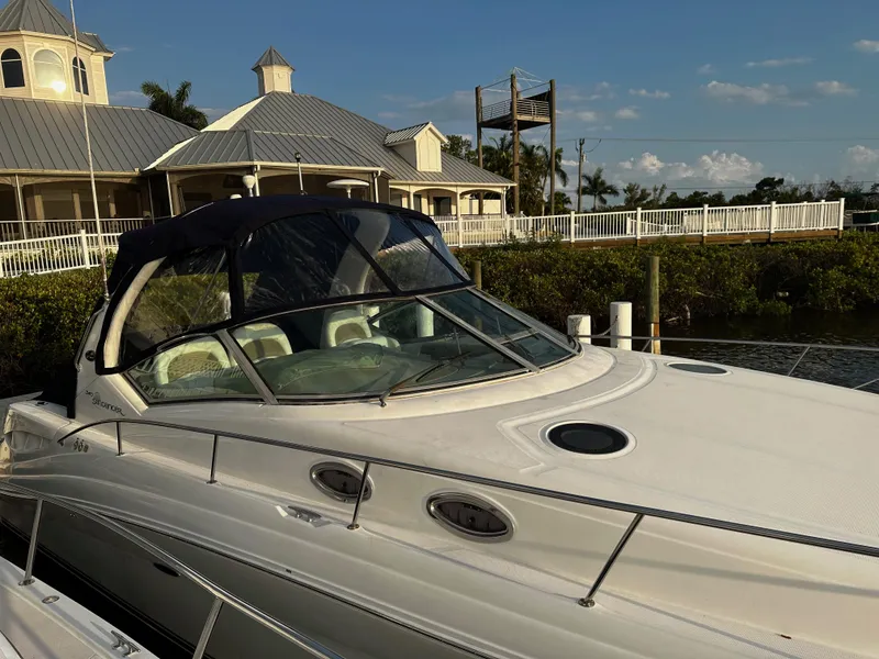 Slide: The Image of 2005 Sea Ray 340 Sundancer docked near waterfront buildings under a clear sky. - 6