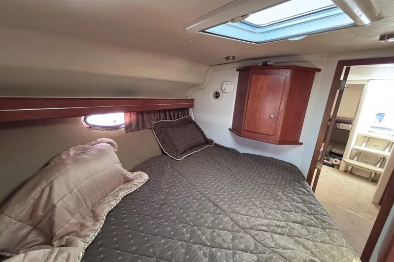 Slide: The Image of 2007 Rinker EX 370 cabin interior with bed, skylight, and wooden cabinet. - 15
