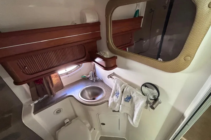 Slide: The Image of 2007 Rinker EX 370 boat bathroom with sink, mirror, and wooden cabinetry. - 18