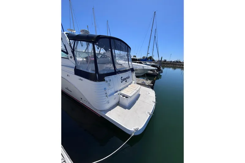 Slide: The Image of 2007 Rinker EX 370 boat docked in a marina under clear blue skies. - 2