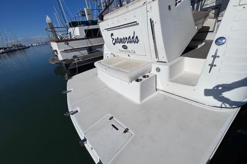 Slide: The Image of 2007 Rinker EX 370 boat docked in a marina, featuring a spacious swim platform. - 21