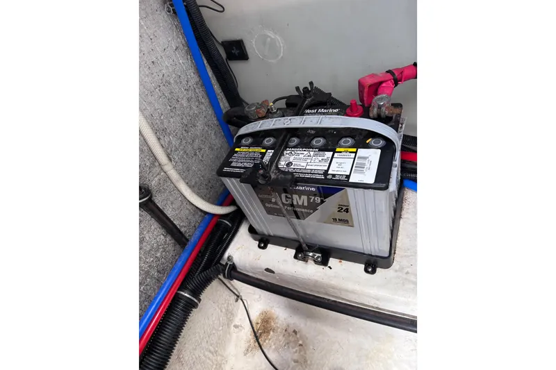 Slide: The Image of Battery compartment of a 2007 Rinker EX 370 boat, featuring a marine battery. - 28