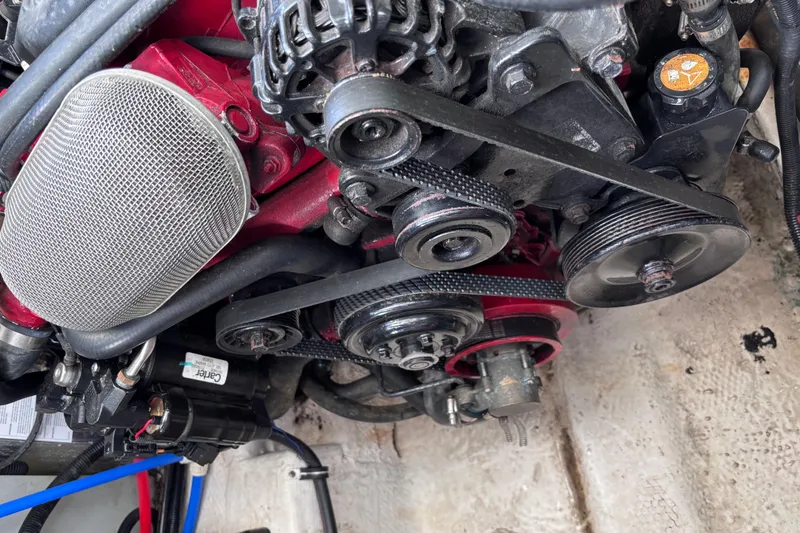 Slide: The Image of Engine components of a 2007 Rinker EX 370 boat, featuring belts and pulleys. - 33