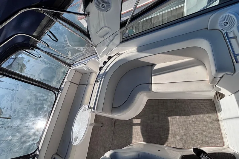 Slide: The Image of Interior of a 2007 Rinker EX 370 boat, featuring plush seating and a round table. - 6