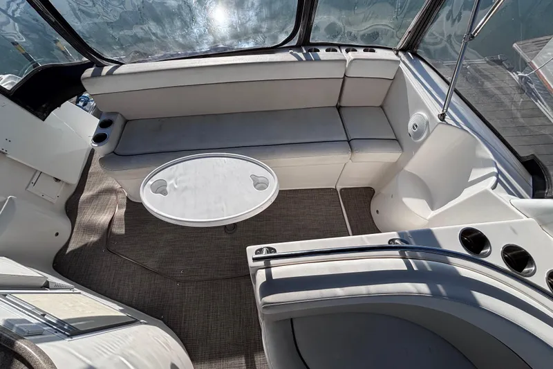 Slide: The Image of 2007 Rinker EX 370 boat interior with seating and table, docked by the water. - 8