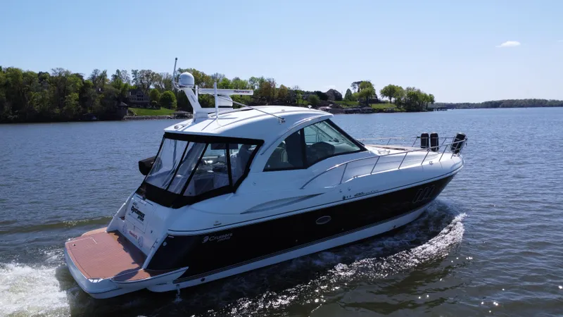 Slide: The Image of 2009 Cruisers Yachts 420 Sports Coupe cruising on a serene lake under a clear blue sky. - 14