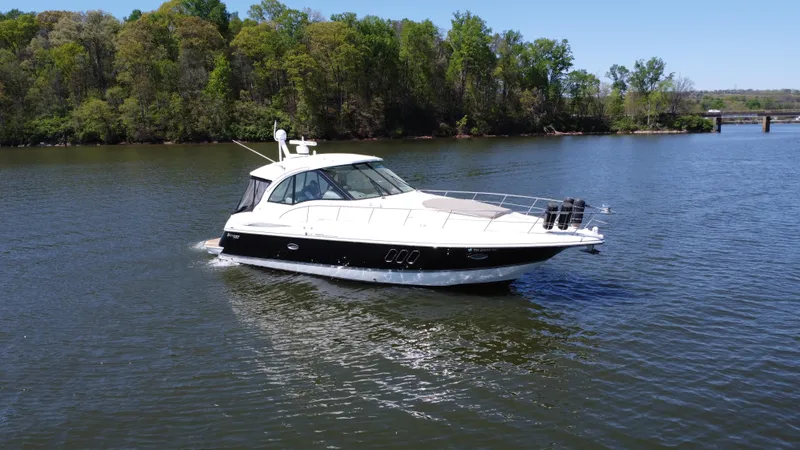 Slide: The Image of 2009 Cruisers Yachts 420 Sports Coupe cruising on a serene lake with lush green trees. - 15