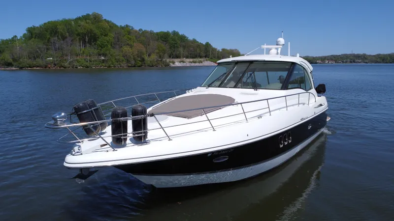 Slide: The Image of 2009 Cruisers Yachts 420 Sports Coupe on calm water, surrounded by lush greenery. - 17