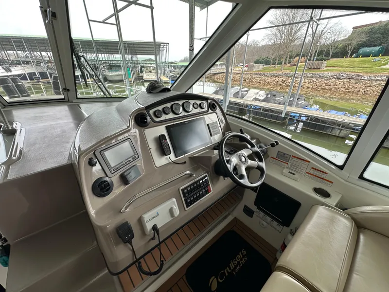 Slide: The Image of 2009 Cruisers Yachts 420 Sports Coupe helm with modern navigation equipment and comfortable seating. - 26