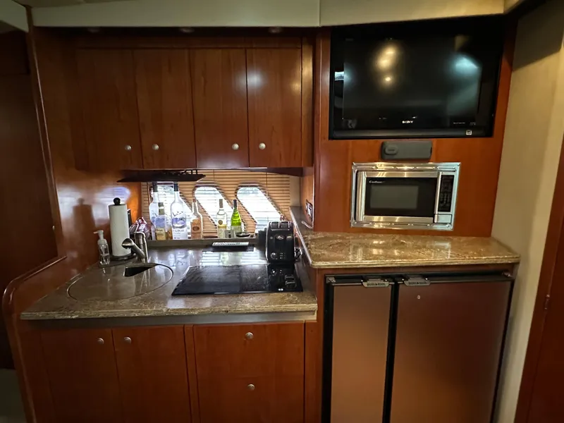 Slide: The Image of 2009 Cruisers Yachts 420 Sports Coupe kitchen with wood cabinets, microwave, and mini fridge. - 37