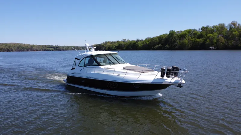Slide: The Image of 2009 Cruisers Yachts 420 Sports Coupe cruising on a serene lake under clear skies. - 9