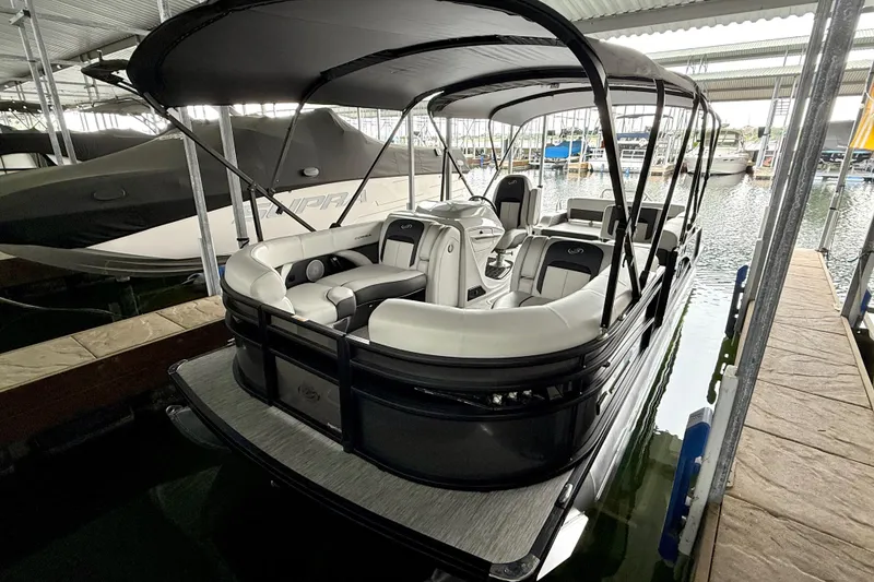 Slide: The Image of 2023 Barletta Corsa 23U pontoon boat docked in a marina, featuring sleek design and spacious seating. - 10