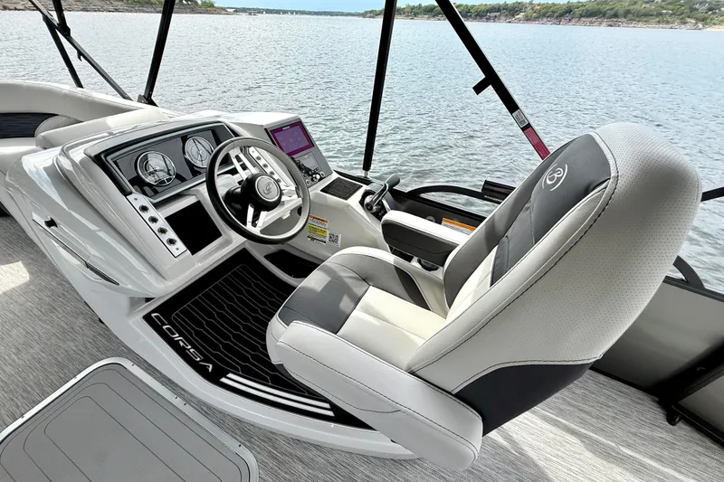 Slide: The Image of 2023 Barletta Corsa 23U boat cockpit with modern steering and controls on a serene lake. - 18