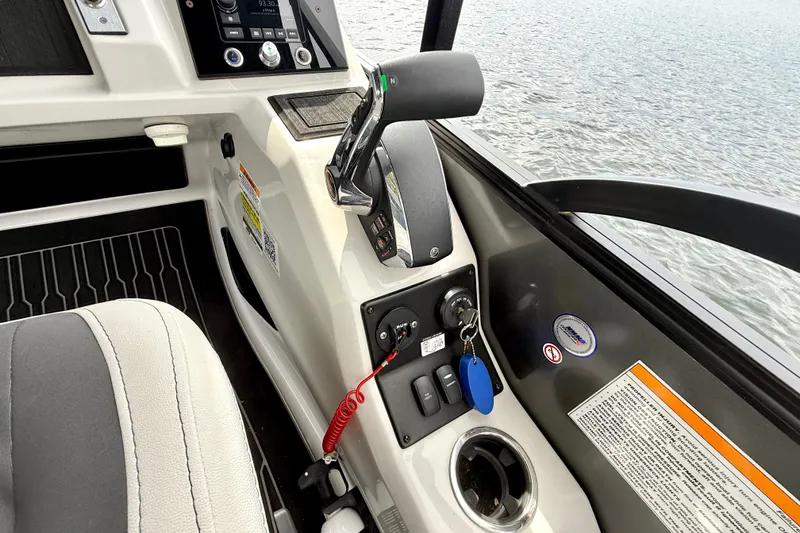 Slide: The Image of Interior view of 2023 Barletta Corsa 23U boat cockpit with controls and water in background. - 20