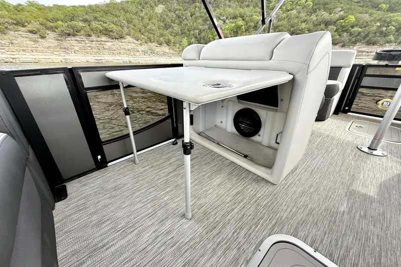 Slide: The Image of 2023 Barletta Corsa 23U pontoon boat interior with foldable table and seating. - 23