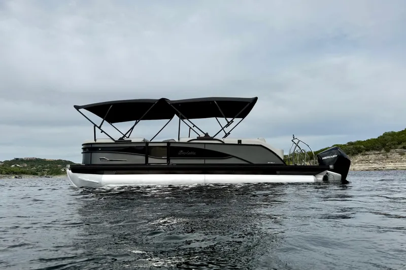Slide: The Image of 2023 Barletta Corsa 23U pontoon boat on water, featuring sleek design and dual canopies. - 7