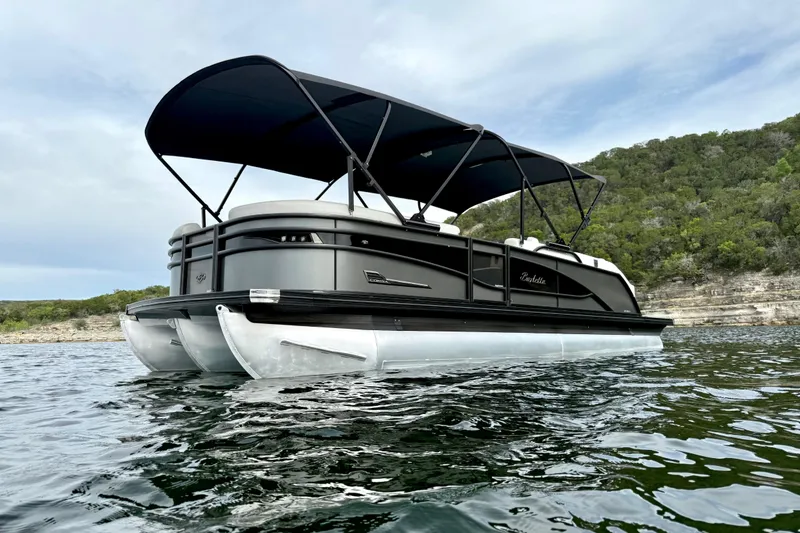 Slide: The Image of 2023 Barletta Corsa 23U pontoon boat on a scenic lake with lush greenery. - 8