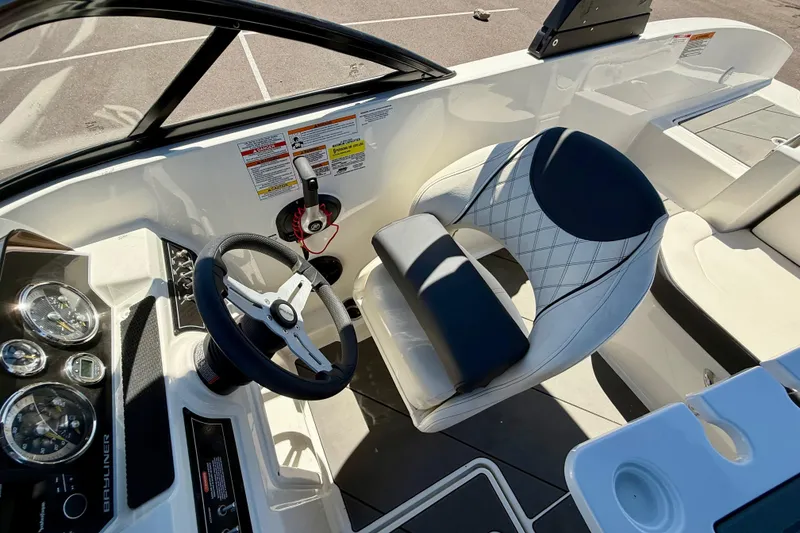 Slide: The Image of 2023 Bayliner DX 2050 boat interior with steering wheel and cushioned seating. - 17