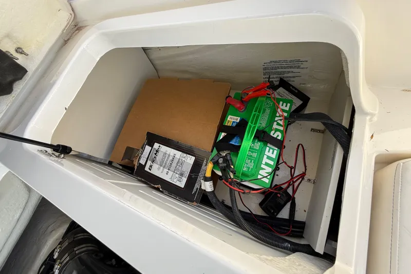 Slide: The Image of Battery compartment of 2023 Bayliner DX 2050 boat with wiring and storage. - 21