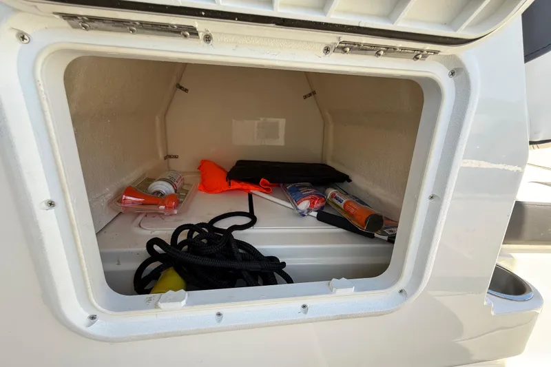 Slide: The Image of Storage compartment of 2023 Bayliner DX 2050 boat with safety gear and rope. - 22