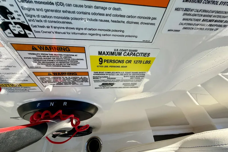 Slide: The Image of 2023 Bayliner DX 2050 capacity warning labels, maximum 9 persons or 1270 lbs. - 24