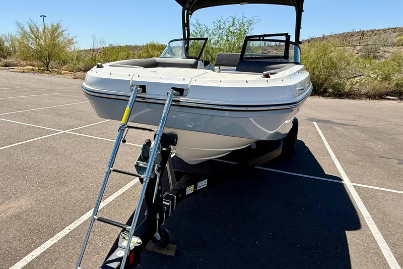 Slide: The Image of 2023 Bayliner DX 2050 boat on trailer in parking lot, sunny day. - 27