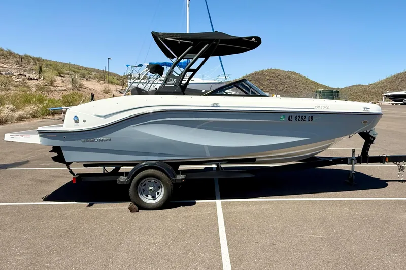 Slide: The Image of 2023 Bayliner DX 2050 boat on trailer in sunny desert landscape. - 4