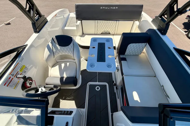 Slide: The Image of 2023 Bayliner DX 2050 boat interior with seating, steering wheel, and table. - 8