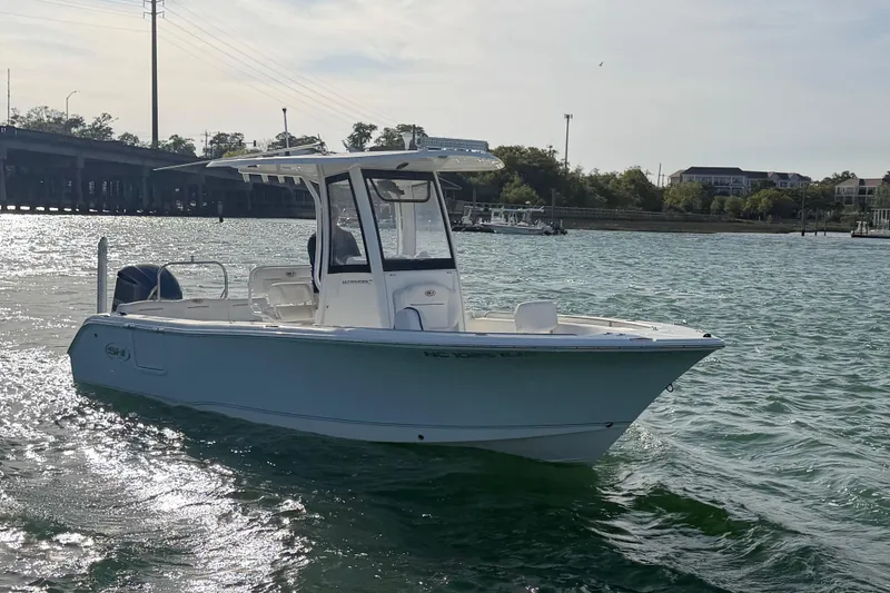 Slide: The Image of 2018 Sea Hunt Ultra 235 SE boat on water near a bridge. - 20