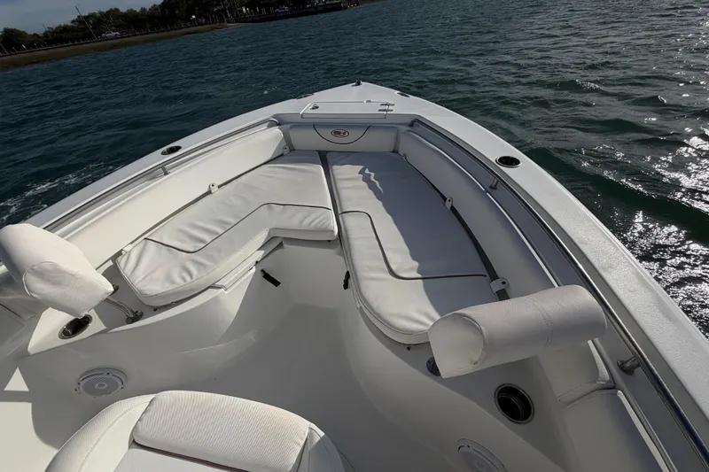 Slide: The Image of 2018 Sea Hunt Ultra 235 SE boat interior with white cushioned seating on open water. - 31
