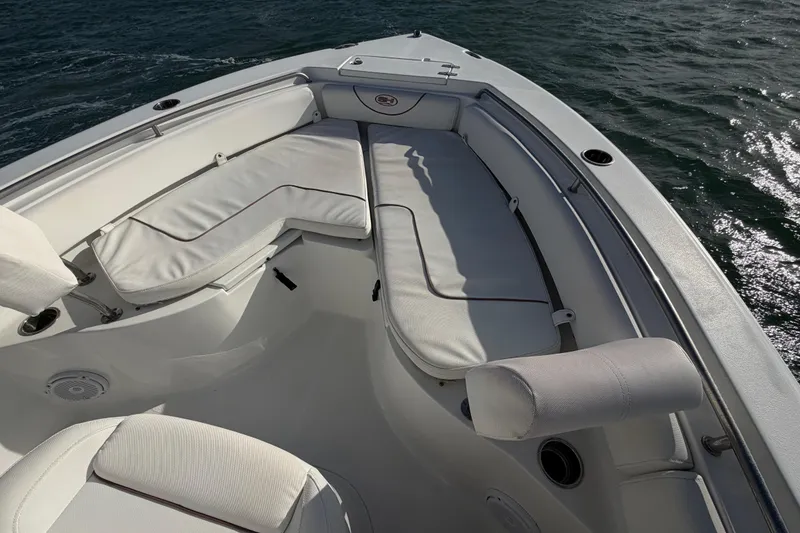 Slide: The Image of 2018 Sea Hunt Ultra 235 SE boat with white cushioned seating on open water. - 36