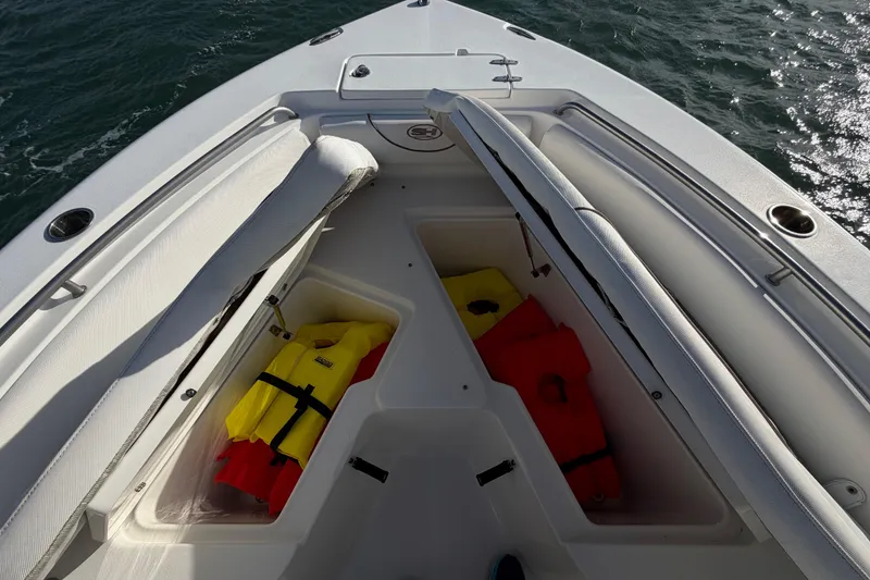 Slide: The Image of 2018 Sea Hunt Ultra 235 SE boat with open storage compartments and life jackets. - 38