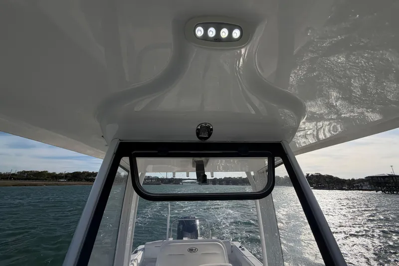 Slide: The Image of 2018 Sea Hunt Ultra 235 SE boat interior view with overhead lighting on water. - 45