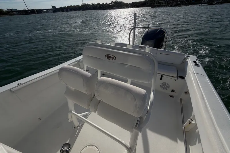 Slide: The Image of 2018 Sea Hunt Ultra 235 SE boat interior with seating, on a sunny day. - 47