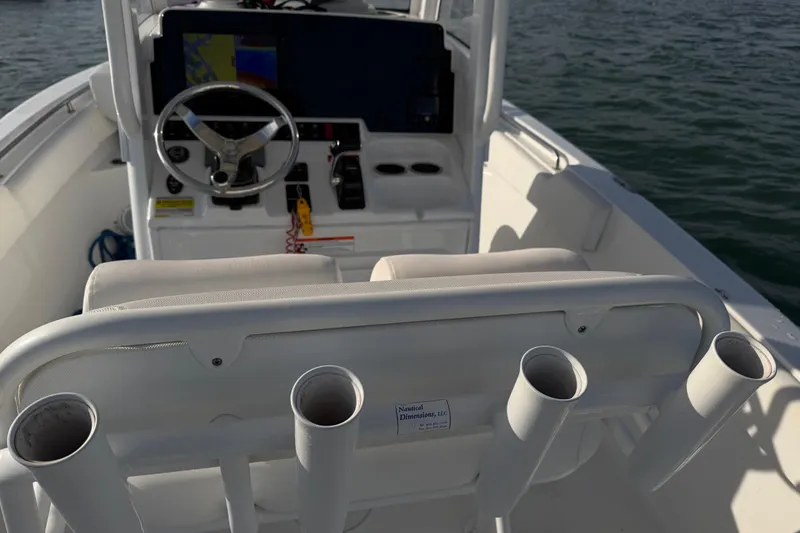 Slide: The Image of 2018 Sea Hunt Ultra 235 SE boat interior with steering wheel and rod holders. - 55