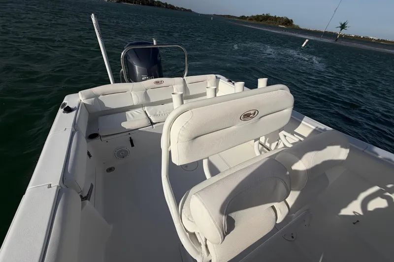 Slide: The Image of 2018 Sea Hunt Ultra 235 SE boat interior with seating and ocean view. - 56