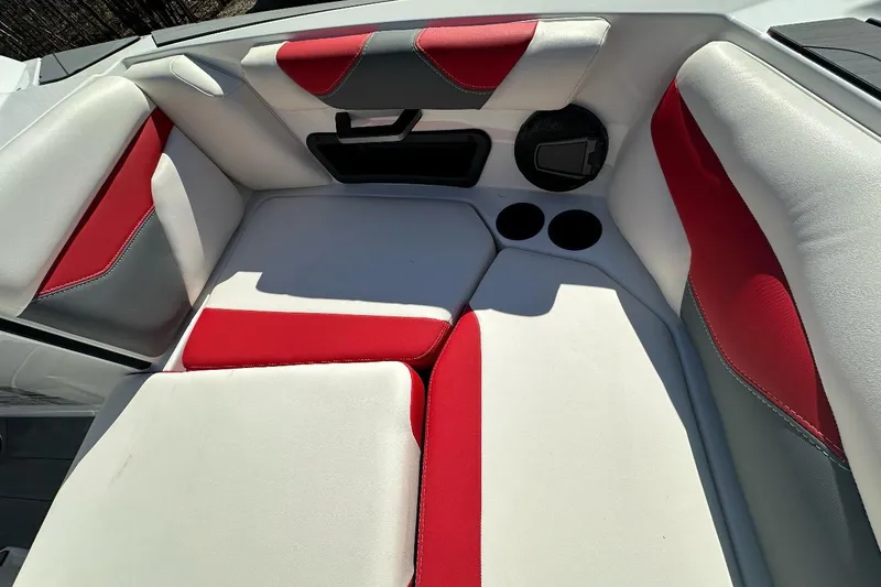 Slide: The Image of 2024 Axis A20 boat interior with red and white cushioned seating and cup holders. - 14