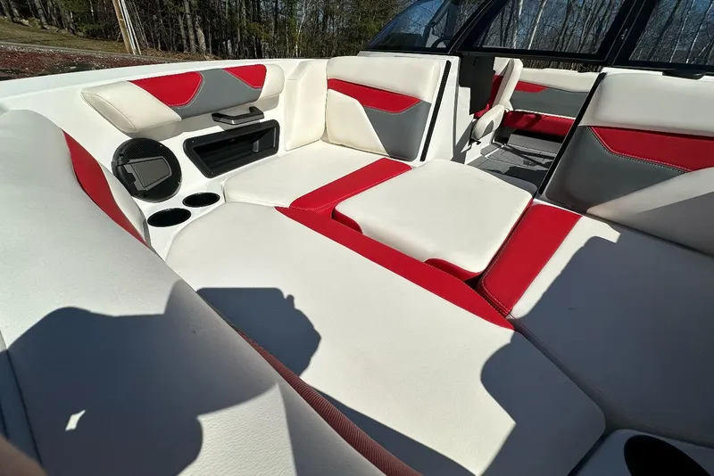 Slide: The Image of 2024 Axis A20 boat interior with red and white seating, cup holders, and speaker system. - 15