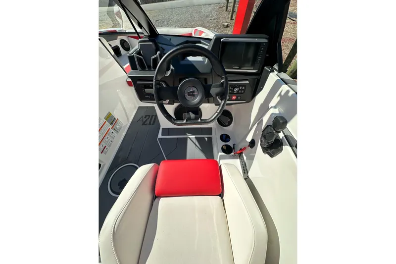 Slide: The Image of 2024 Axis A20 boat cockpit with steering wheel, dashboard, and red-accented seating. - 16