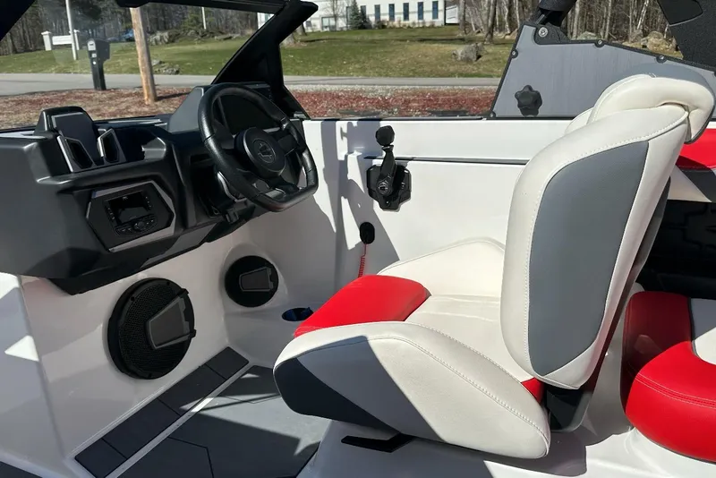 Slide: The Image of 2024 Axis A20 boat interior with modern steering, red and white seating, and audio system. - 17