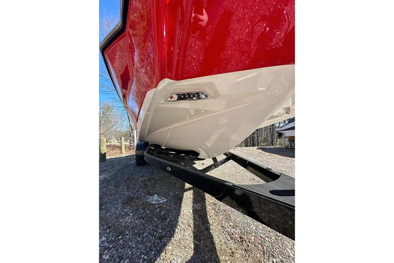 Slide: The Image of 2024 Axis A20 boat hull in red and white on a trailer, outdoor setting. - 23