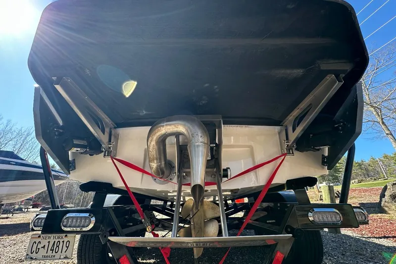 Slide: The Image of Rear view of 2024 Axis A20 boat on trailer, showcasing exhaust and license plate. - 24