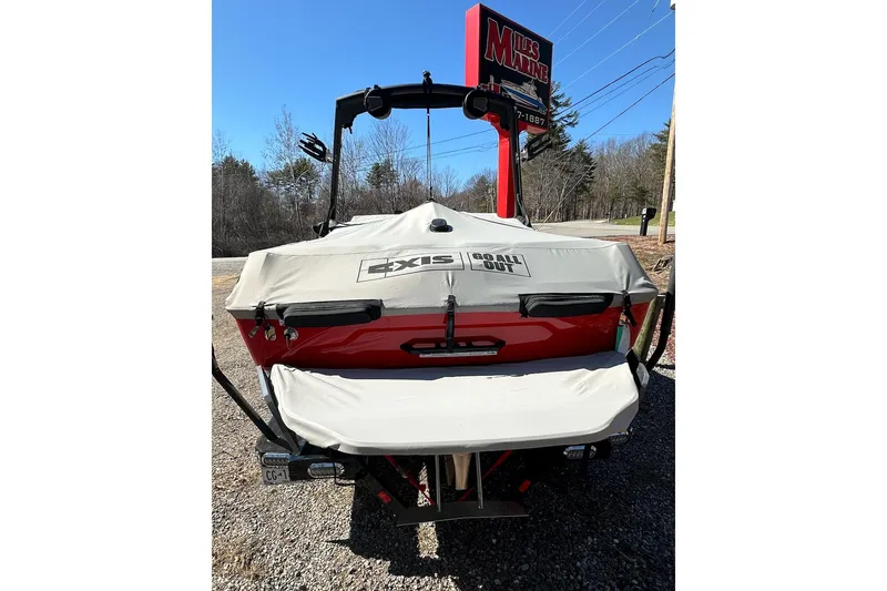 Slide: The Image of 2024 Axis A20 boat with cover, parked outdoors near dealership sign. - 27