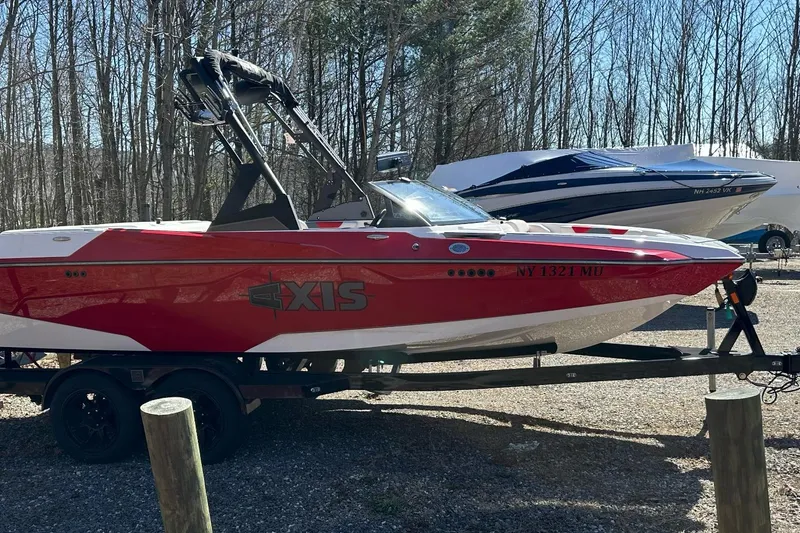 Slide: The Image of 2024 Axis A20 boat in vibrant red on a trailer, parked outdoors. - 4