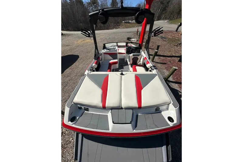 Slide: The Image of 2024 Axis A20 boat interior with red and white seating, docked outdoors. - 8