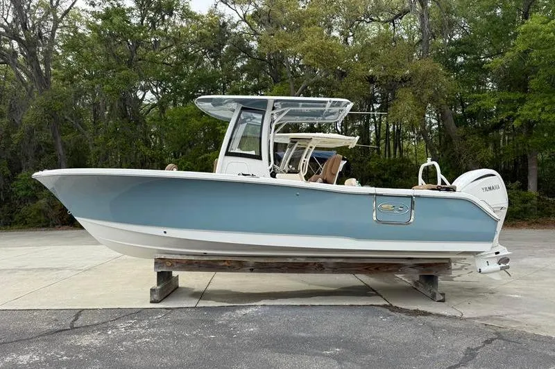The Image of 2023 Sea Hunt Ultra 255 SE boat in light blue, displayed outdoors on a stand. - 0