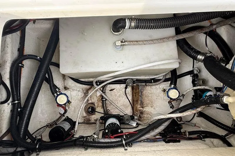 Slide: The Image of Engine compartment of 2023 Sea Hunt Ultra 255 SE with visible hoses and wiring. - 11