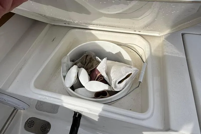 Slide: The Image of Storage compartment on 2023 Sea Hunt Ultra 255 SE boat with cleaning supplies. - 12