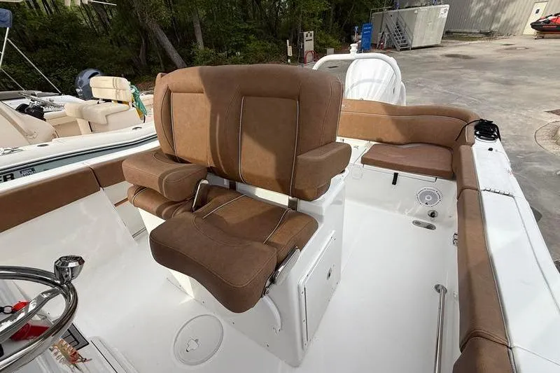 Slide: The Image of 2023 Sea Hunt Ultra 255 SE boat interior with brown cushioned seating and steering wheel. - 17